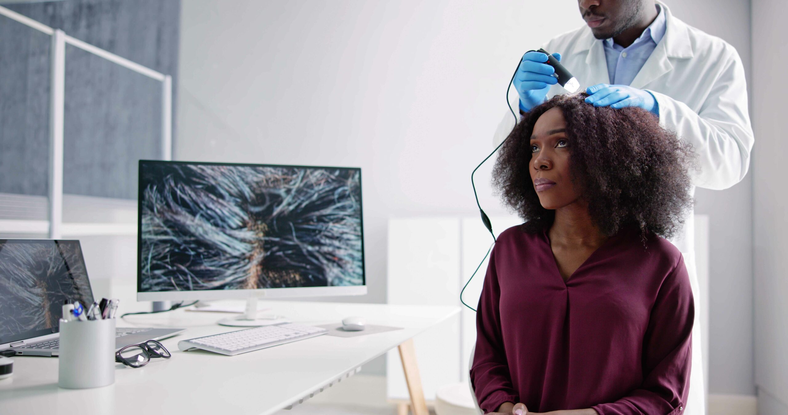 A female patient receiving a trichoscopy assessment from a dermatologist